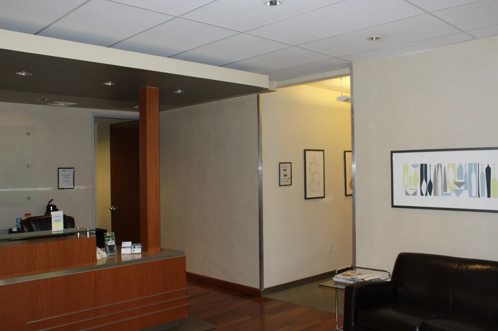 Warm reception counter with leather lounge seating and wall artwork.