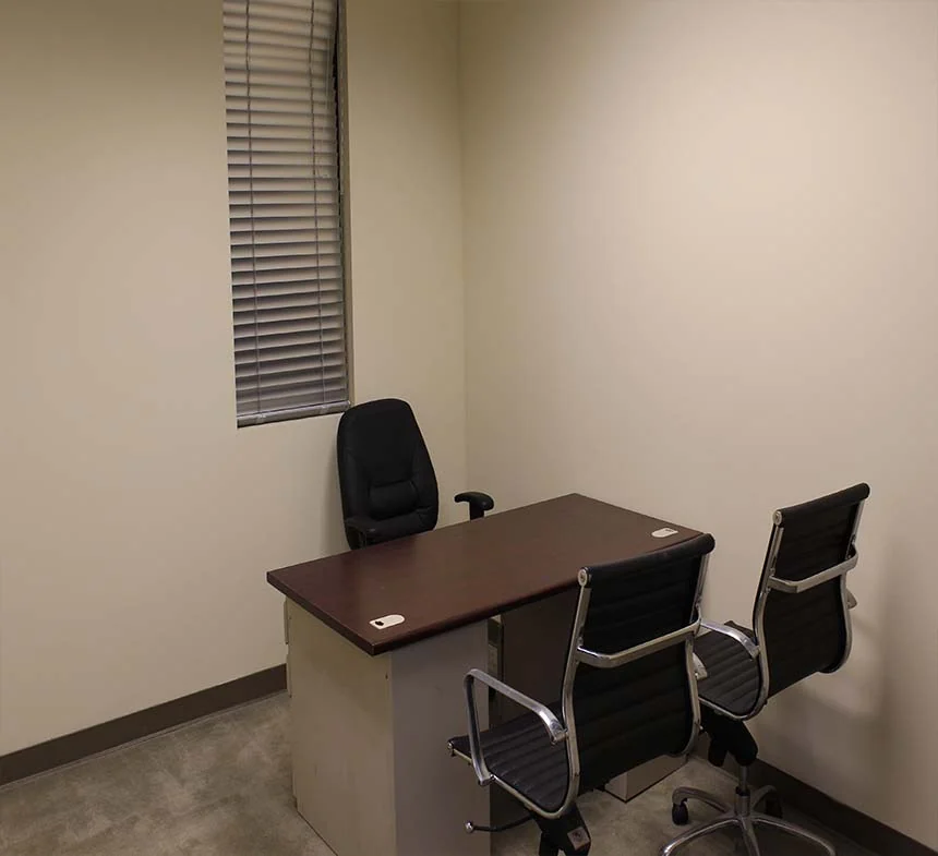 Private office with a desk, task chair, two visitor chairs and a window.